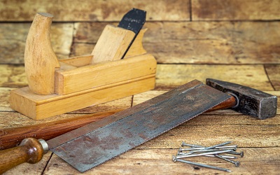 Tools on a tabletop, including a planer and hammer